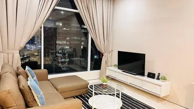 a living room with a couch and a large window at Soho Suites KLCC by Angel in Kuala Lumpur