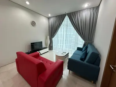 a living room with two red and blue chairs and a television at Soho Suites KLCC by Angel in Kuala Lumpur