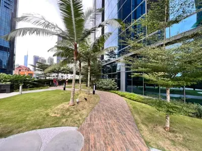 a park with palm trees in front of a building at Eaton Suites KLCC Kuala Lumpur in Kuala Lumpur