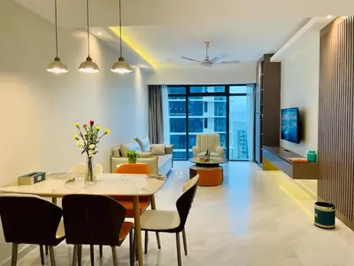 a dining room and living room with a table and chairs at Eaton Suites KLCC Kuala Lumpur in Kuala Lumpur