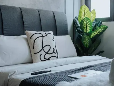 a couch with a pillow and a remote control on it at Riveria City KL Sentral by Sky Pool Minshuku in Kuala Lumpur