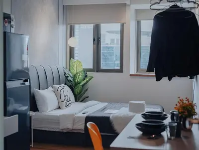 a living room with a bed and a table and a kitchen at Riveria City KL Sentral by Sky Pool Minshuku in Kuala Lumpur