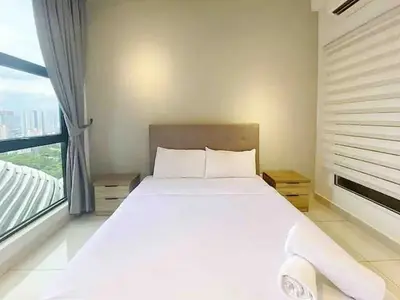 a white bed in a room with a large window at Regalia Resident by Great Stay in Kuala Lumpur