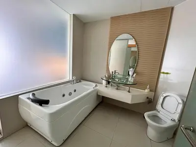 a bathroom with a tub and a toilet and a mirror at Private Jacuzzi Suite - Pertama Residency in Kuala Lumpur