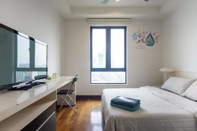a bedroom with a bed and a desk with a flat screen tv at Yelloduck Rooms & Apartment @ Casa Residency in Kuala Lumpur