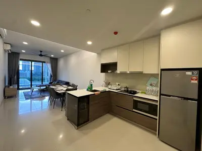 a kitchen with a refrigerator and a table in it at KL Eco City Apartment by Homeizing in Kuala Lumpur