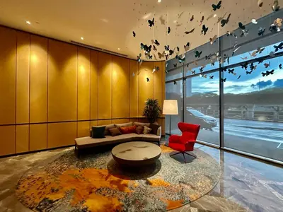 a living room with a couch and a red chair at KL Eco City Apartment by Homeizing in Kuala Lumpur