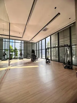 an empty room with a gym with wood floors and windows at Luxury 2BR KL View, Infinity Pool, Walk to Pavilion and Jalan Alor in Kuala Lumpur
