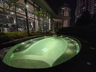 a green pool in front of a building at night at The Ooak Mont Kiara 33A# Main Street Sunway 163#1 bedroom 1-2Pax in Kuala Lumpur