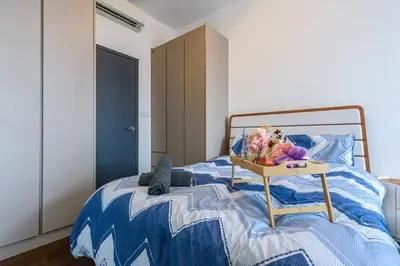 a bedroom with a bed with a table with flowers on it at Cozy KL Sunway Velocity Residence for 1-5pax connected to MRT & Malls in Kuala Lumpur