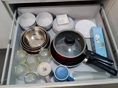 a drawer with a pot and plates and other dishes at Cozy KL Sunway Velocity Residence for 1-5pax connected to MRT & Malls in Kuala Lumpur