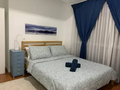 a teddy bear sitting on a bed in a bedroom at Menara Arina Uniti in Kuala Lumpur