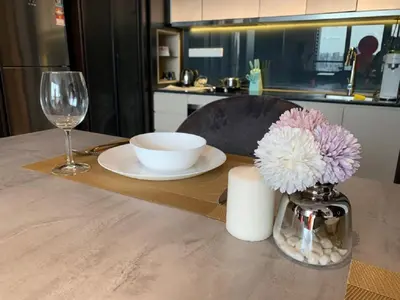a table with a candle and a vase with flowers at Luxury Apartment at Scarletz Suites Kuala Lumpur in Kuala Lumpur