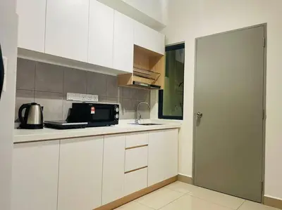 a kitchen with white cabinets and a black microwave at M Vertica Residences@KL in Kuala Lumpur