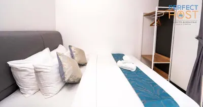 a bedroom with a white bed with pillows at Neu Suites @ 3rdNvenue by Perfect Host in Kuala Lumpur