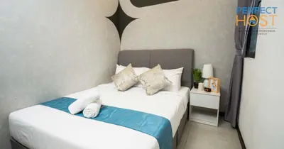 a bedroom with a bed with two pillows at Neu Suites @ 3rdNvenue by Perfect Host in Kuala Lumpur