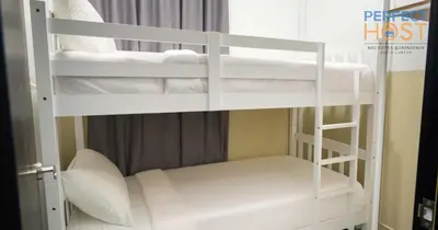 two bunk beds in a room with white towels at Neu Suites @ 3rdNvenue by Perfect Host in Kuala Lumpur