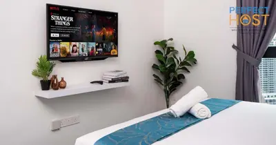 a bedroom with a tv hanging on the wall at Neu Suites @ 3rdNvenue by Perfect Host in Kuala Lumpur