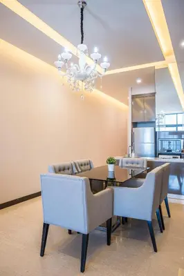 a dining room with a table and chairs and a chandelier at Dorsett Residence Kuala Lumpur \u5e1d\u76db\u516c\u5bd3 Bukit Bintang in Kuala Lumpur