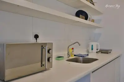 a white kitchen with a sink and a counter at Arte plus by 2BR sweet home in Kuala Lumpur