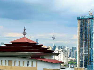 a building with a red roof in front of a city at Court 28 Residence KL Suites 2 Bedroom Apartment by Sleepy Bear in Kuala Lumpur