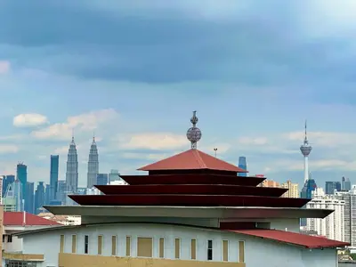 a building with a red roof with a city in the background at Court 28 Residence KL Suites 2 Bedroom Apartment by Sleepy Bear in Kuala Lumpur