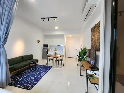a living room with a green couch and a table at Chambers Residences Suites KLCC in Kuala Lumpur