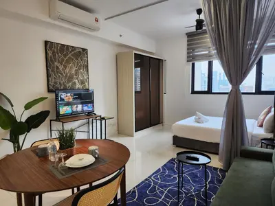 a living room with a bed and a dining room at Chambers Residences Suites KLCC in Kuala Lumpur