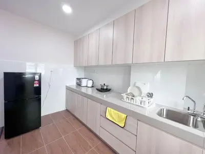 a kitchen with a black refrigerator and a sink at Maison Signature Suites in Kuala Lumpur