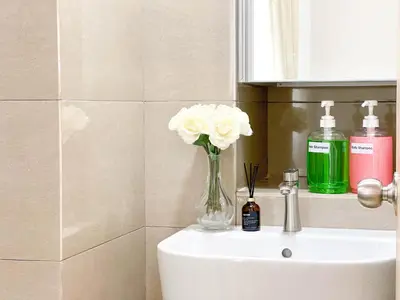 a vase of flowers sitting on top of a sink at Maison Signature Suites in Kuala Lumpur