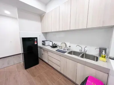 a kitchen with a black refrigerator and a sink at Maison Signature Suites in Kuala Lumpur