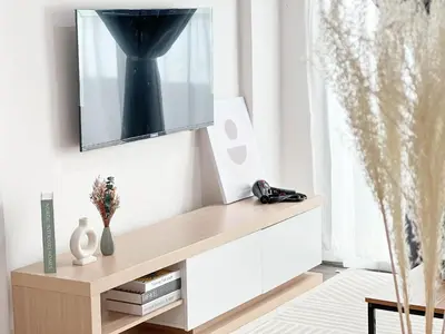 a living room with a tv on a white wall at Maison Signature Suites in Kuala Lumpur