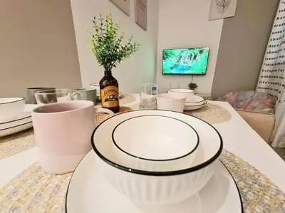 a dining room table with white plates on it at KL Creamy Tiny 2R1B Home \u7206\u6b3e\u5976\u6cb9\u98ce\u5c0f\u5b85 in Kuala Lumpur