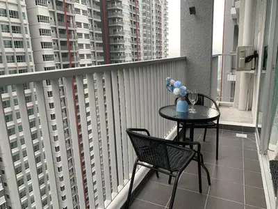 a table and chairs on a balcony with buildings at Corner KL Pool View RC Residence with High Internet Speed 500Mbps in Kuala Lumpur