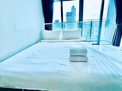 a white bed in a room with a large window at Summer suites victory house in Kuala Lumpur