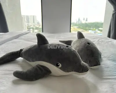 a stuffed animal shark laying on a bed at Trion - KL - 2BR - 6pax - 15min to KLCC & TRX in Kuala Lumpur