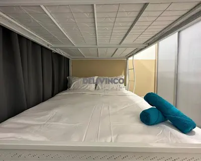 a bed with a blue pillow on top of it at Trion - KL - 2BR - 6pax - 15min to KLCC & TRX in Kuala Lumpur