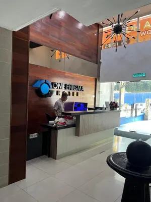 a man standing at a counter in a restaurant at One Enigma Hotel in Kuala Lumpur