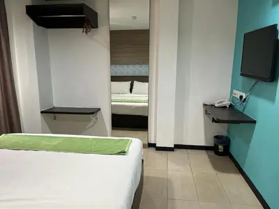 a small room with a bed and a television at One Enigma Hotel in Kuala Lumpur
