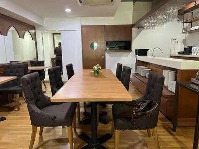a dining room with a wooden table and chairs at One Enigma Hotel in Kuala Lumpur