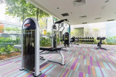 a gym with treadmills and ellipticals in a building at Mercu Summer Suites KLCC 2BR Pastel Rose in Kuala Lumpur