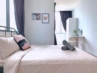 a bedroom with a bed with a pillow on it at Mercu Summer Suites KLCC 2BR Pastel Rose in Kuala Lumpur