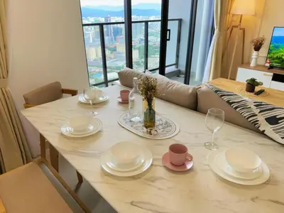 a dining room table with plates and wine glasses at 3R3B KLCity CentreView (Balcony) - 8 pax in Kuala Lumpur