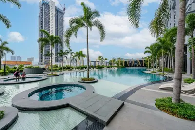 a large swimming pool with palm trees and buildings at Trion Premier Suites Kuala Lumpur in Kuala Lumpur