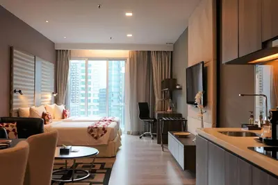 a hotel room with a bed and a sink at Ramada Suites by Wyndham Kuala Lumpur City Centre in Kuala Lumpur