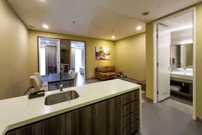 a kitchen with a sink and a living room at Ramada Suites by Wyndham Kuala Lumpur City Centre in Kuala Lumpur