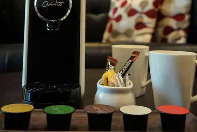 a table with a coffee maker and a cup of toothbrushes at Ramada Suites by Wyndham Kuala Lumpur City Centre in Kuala Lumpur