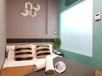 a bedroom with a bed with fur pillows at Leo Leisure Hotel @ Central Market in Kuala Lumpur
