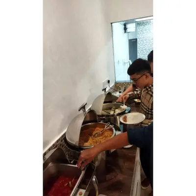 two people preparing food in a restaurant kitchen at Sakura Elite Kuala Lumpur in Kuala Lumpur