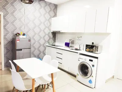 a kitchen with a washing machine and a table at Arte plus by studio sweet home in Batu Empat